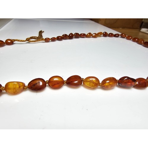 241 - A good quality vintage hand knotted genuine amber beaded necklace, each bead has an interesting natu... 