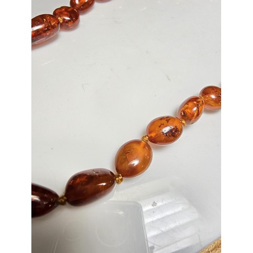 241 - A good quality vintage hand knotted genuine amber beaded necklace, each bead has an interesting natu... 