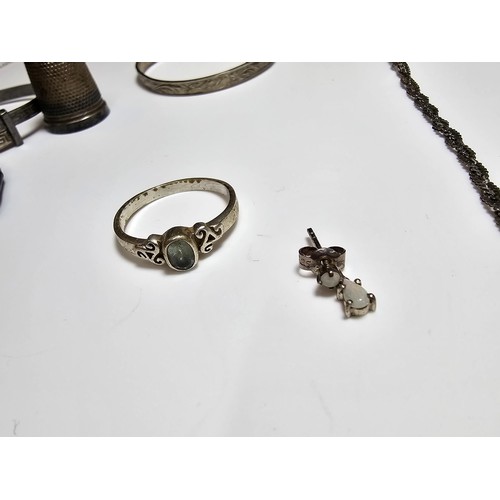 280 - A quantity of 925 silver items to include 2 Christening bangles, a silver ring inset with a topaz st... 