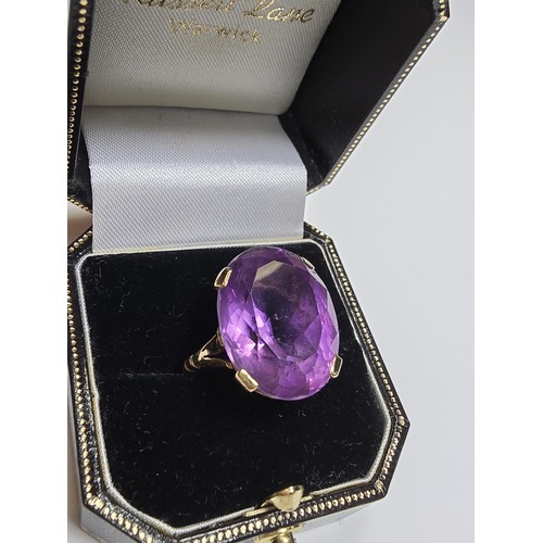 304 - A 9ct yellow gold dress ring inset with a large impressive faceted amethyst gemstone (tested), set i... 