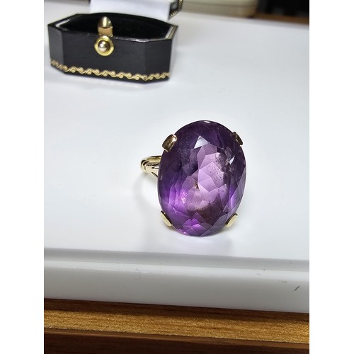 304 - A 9ct yellow gold dress ring inset with a large impressive faceted amethyst gemstone (tested), set i... 