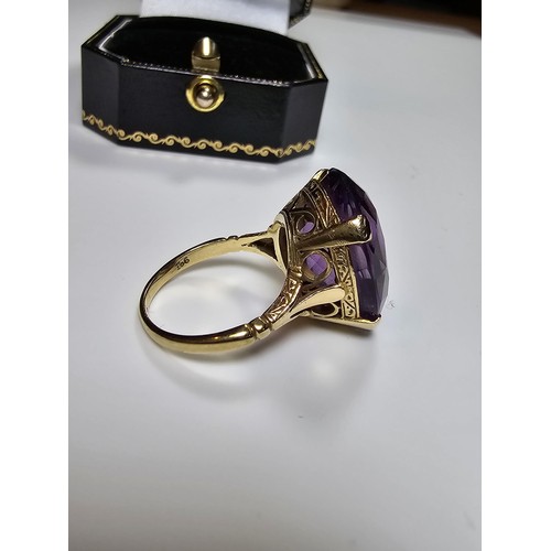 304 - A 9ct yellow gold dress ring inset with a large impressive faceted amethyst gemstone (tested), set i... 