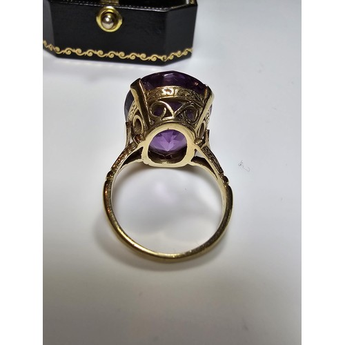 304 - A 9ct yellow gold dress ring inset with a large impressive faceted amethyst gemstone (tested), set i... 