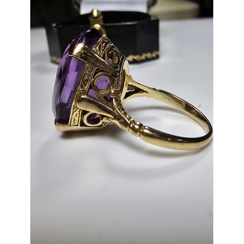 304 - A 9ct yellow gold dress ring inset with a large impressive faceted amethyst gemstone (tested), set i... 