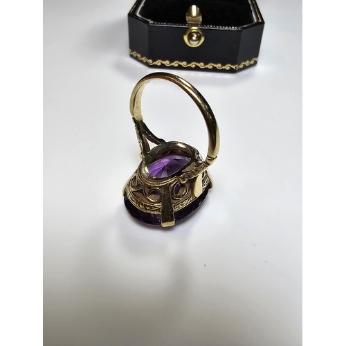 304 - A 9ct yellow gold dress ring inset with a large impressive faceted amethyst gemstone (tested), set i... 