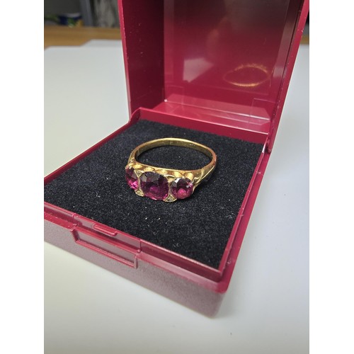 305 - An 18ct yellow gold 3 stone ring inset with 3 large and impressive almandine garnet stones presentin... 