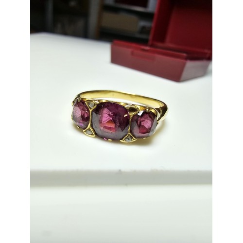 305 - An 18ct yellow gold 3 stone ring inset with 3 large and impressive almandine garnet stones presentin... 