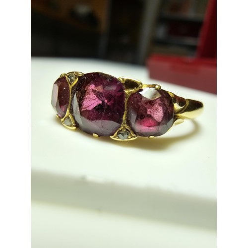 305 - An 18ct yellow gold 3 stone ring inset with 3 large and impressive almandine garnet stones presentin... 