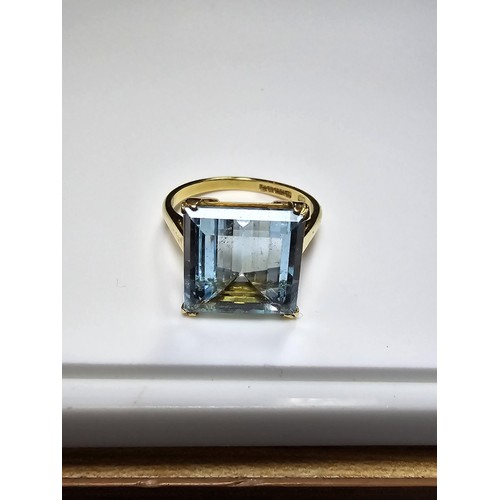 307 - An impressive 18ct yellow gold dress ring inset with a large faceted aqua marine stone of excellent ... 