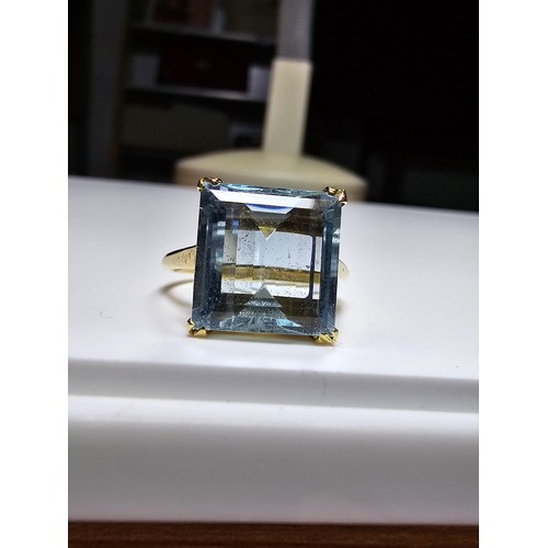 307 - An impressive 18ct yellow gold dress ring inset with a large faceted aqua marine stone of excellent ... 