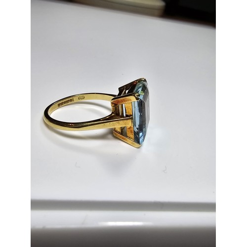 307 - An impressive 18ct yellow gold dress ring inset with a large faceted aqua marine stone of excellent ... 