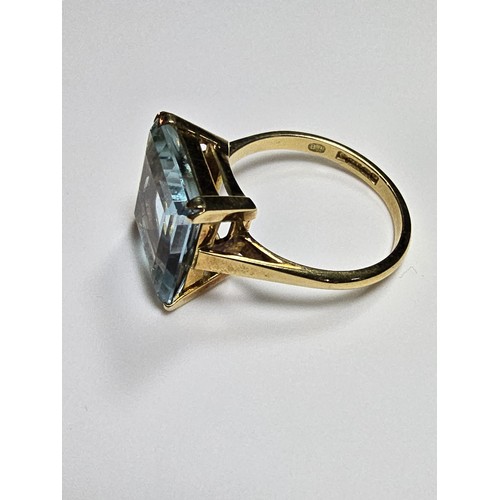 307 - An impressive 18ct yellow gold dress ring inset with a large faceted aqua marine stone of excellent ... 