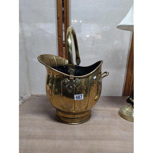 487 - A pair of brass items including a good quality coal scuttle with handle along with a brass lamp with... 