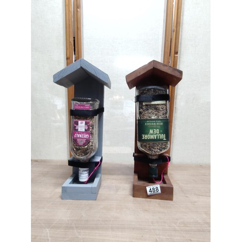 488 - 2x hand made bird feeders, each with a bottle filled with sead, self filling tray, height of 39cm