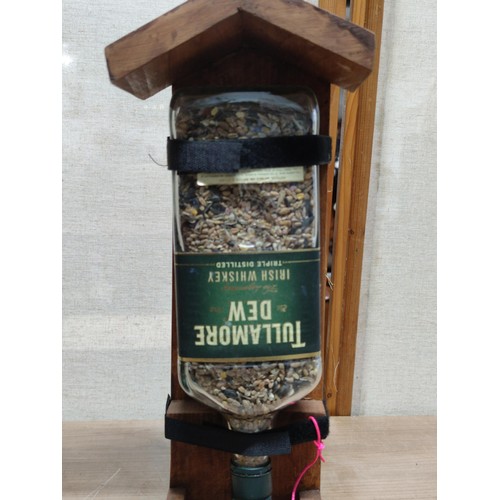 488 - 2x hand made bird feeders, each with a bottle filled with sead, self filling tray, height of 39cm