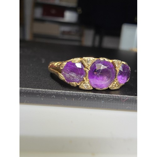 316 - A hallmarked 9ct yellow gold 3 stone ring inset with 3 faceted amethyst stones, in good clean condit... 