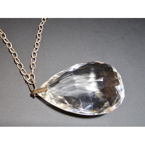 323 - A very large and impressive quarts rock crystal faceted pendant set on a long 24