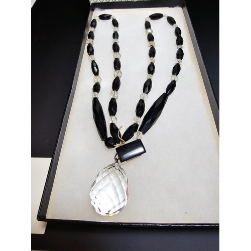 324 - A good crystal necklace to include a large quartz rock crystal faceted pendant with jet and crystal ... 