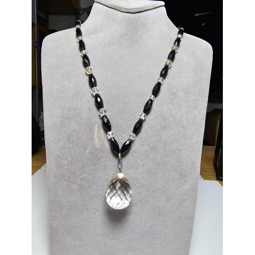 324 - A good crystal necklace to include a large quartz rock crystal faceted pendant with jet and crystal ... 