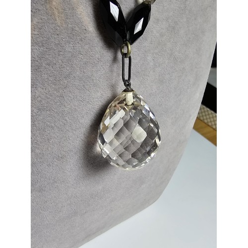 324 - A good crystal necklace to include a large quartz rock crystal faceted pendant with jet and crystal ... 