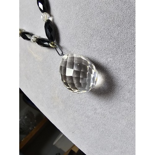 324 - A good crystal necklace to include a large quartz rock crystal faceted pendant with jet and crystal ... 