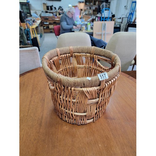 517 - Wicker woven basket with rope wound rim in tidy condition its diameter 38cm