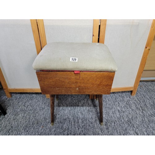 529 - Mahogany sewing stool box on legs with green dralon padded top and red lining.