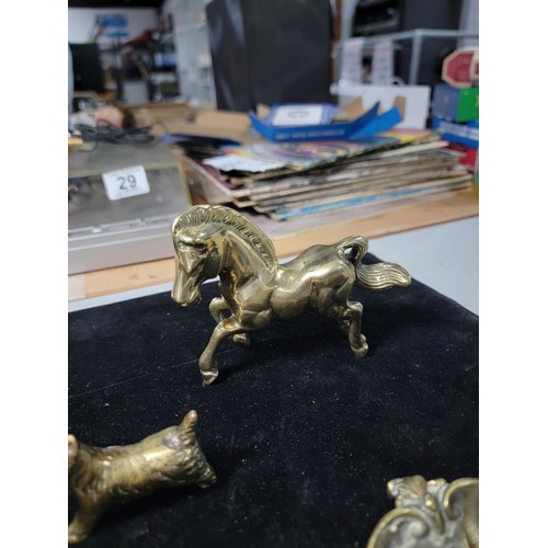 338 - A brass owl a brass horse at walk a brass horse lying down a brass dog a candle holder and a small c... 