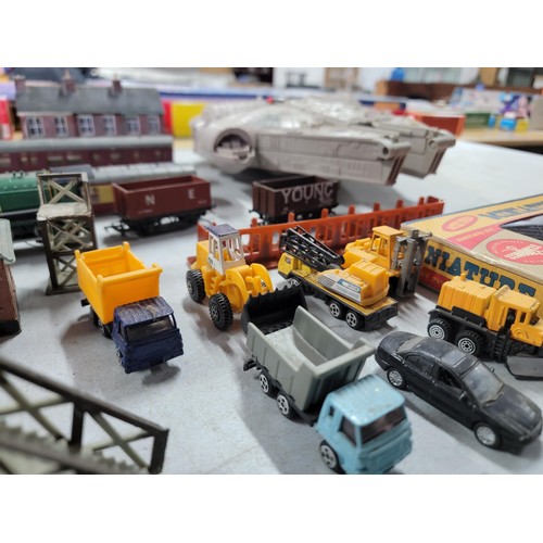 75 - A box containing a quantity of model train items including carriages, wagons, buildings, platforms, ... 