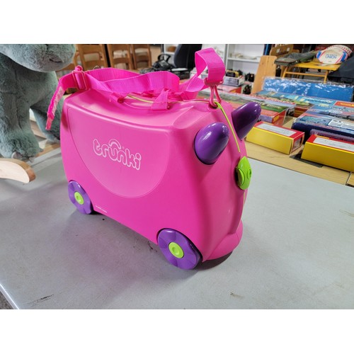 76 - A children's rocking triceratops dinosaur in good condition along with a Trunki children's travel su... 