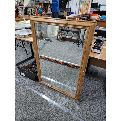 87 - A pine framed bevel edged mirror in good condition.
Height is 73cm, length of 104cm.