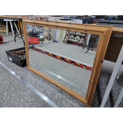 87 - A pine framed bevel edged mirror in good condition.
Height is 73cm, length of 104cm.