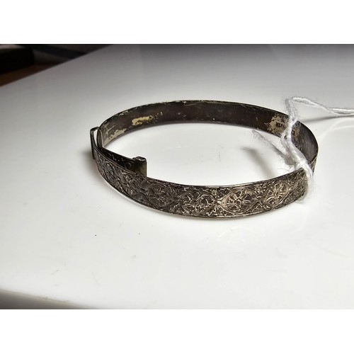 177 - An adult size adjustable vintage sterling silver bangle with an engraved design to the band, in good... 