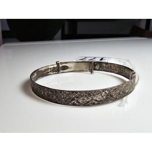 177 - An adult size adjustable vintage sterling silver bangle with an engraved design to the band, in good... 