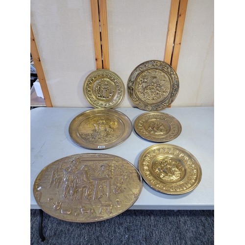 439 - Collection of 6x brass antique chargers depicting various scenes inc ships, tavern, Welsh Lady, larg... 