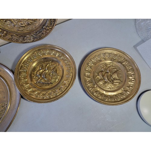 439 - Collection of 6x brass antique chargers depicting various scenes inc ships, tavern, Welsh Lady, larg... 