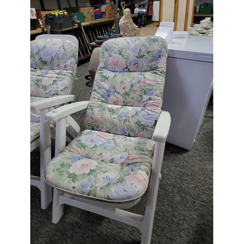 455 - 2x white plastic recliner garden chairs complete with floral cushions in overall good condition fold... 