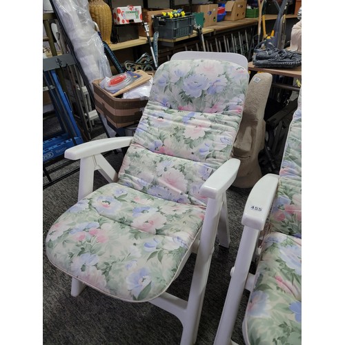 455 - 2x white plastic recliner garden chairs complete with floral cushions in overall good condition fold... 