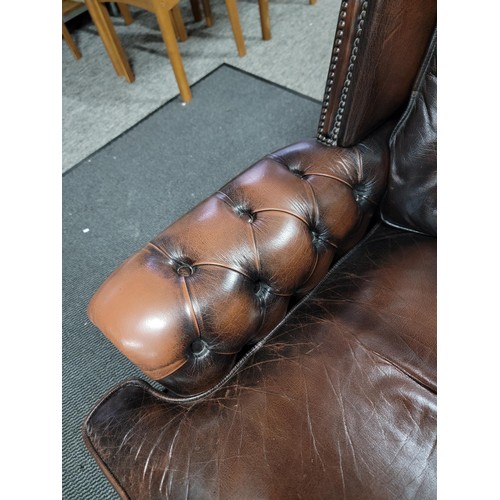 458 - Good quality brown leather wing back Chesterfield style button back and button arm chair, studded to... 