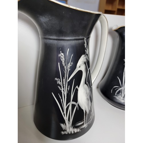 153 - Pair of large Lawleys black and white egret decorated jugs, both jugs have gilding to the handles, o... 