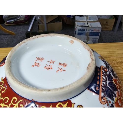 162 - A large antique Chinese bowl with a thick enamel hand painted design featuring a scene of sprays of ... 