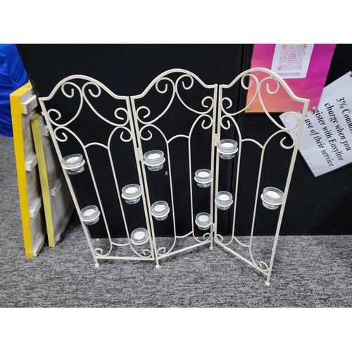 92 - A wrought iron tri-fold candle firescreen with 11x glass tea light holders, height 73cm length 65cm