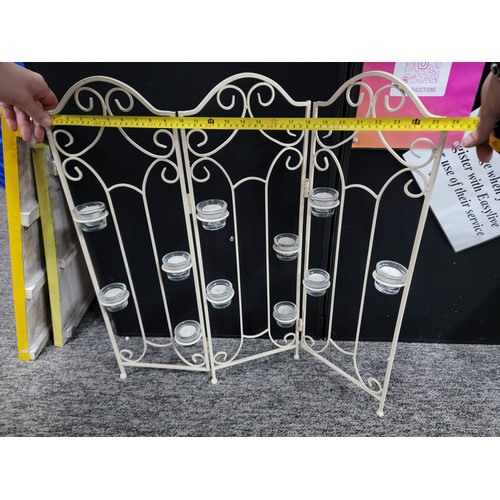 92 - A wrought iron tri-fold candle firescreen with 11x glass tea light holders, height 73cm length 65cm