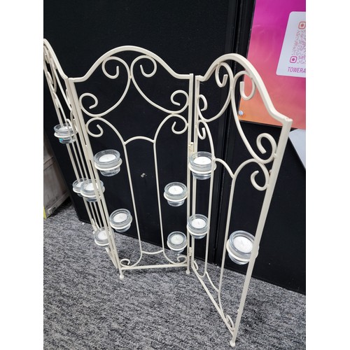 92 - A wrought iron tri-fold candle firescreen with 11x glass tea light holders, height 73cm length 65cm