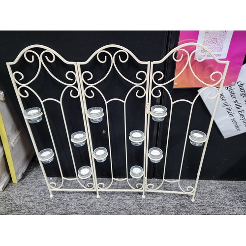 92 - A wrought iron tri-fold candle firescreen with 11x glass tea light holders, height 73cm length 65cm