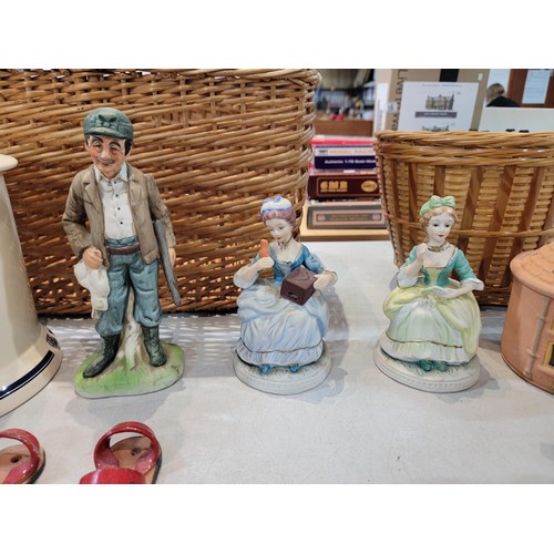 99 - A wicker shopping basket containing a quantity of collectables including 4 Victorian style figurines... 