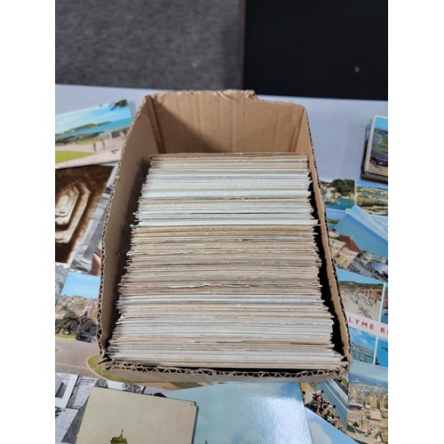 287 - A small box containing a very large quantity of various postcards including postcards from locations... 