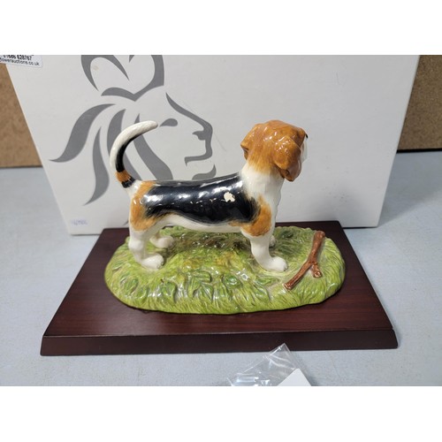 292 - A boxed Royal Doulton Beagle figure RDA 11, hand decorated figurine, standing on a wooden plinth, ha... 