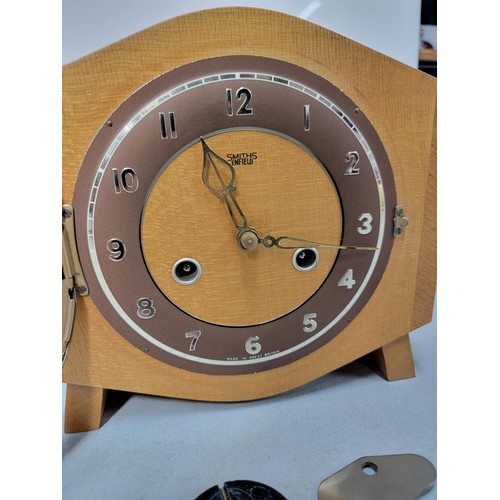 302 - A light oak Smiths Enfield mantel clock striking on a coiled gong and complete with key and pendulum... 