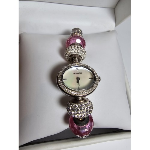 190 - a Charmed by Accurist ladies wrist watch having a Mother of Pearl dial and a jewelled charm bracelet... 